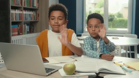 Little African American boys kids students pupils schoolboys brothers children at school education classroom online online video call distant studying teacher hello e-learning internet laptop computer - Powered by Shutterstock - Get 15% off with code: PIKWIZARD15