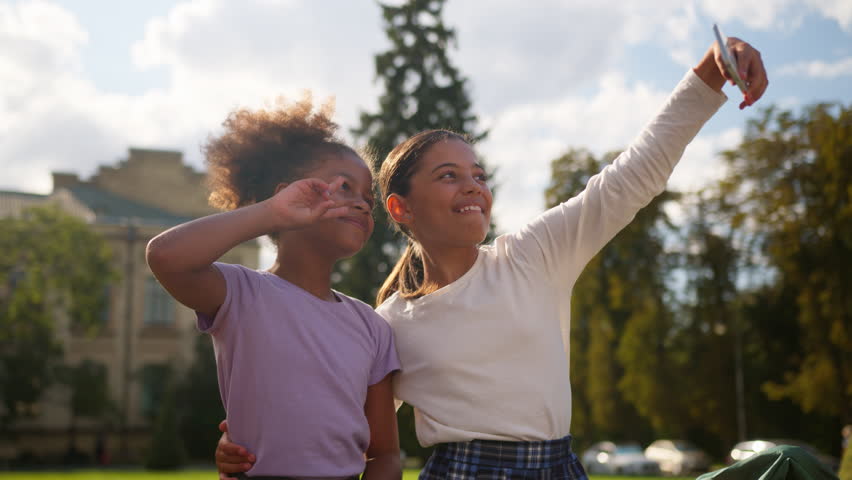 School education Indian African multiethnic little girls students pupils schoolgirls outdoor gadget addict mobile phone posing photo female children friends sisters teen bloggers kids selfie blog vlog