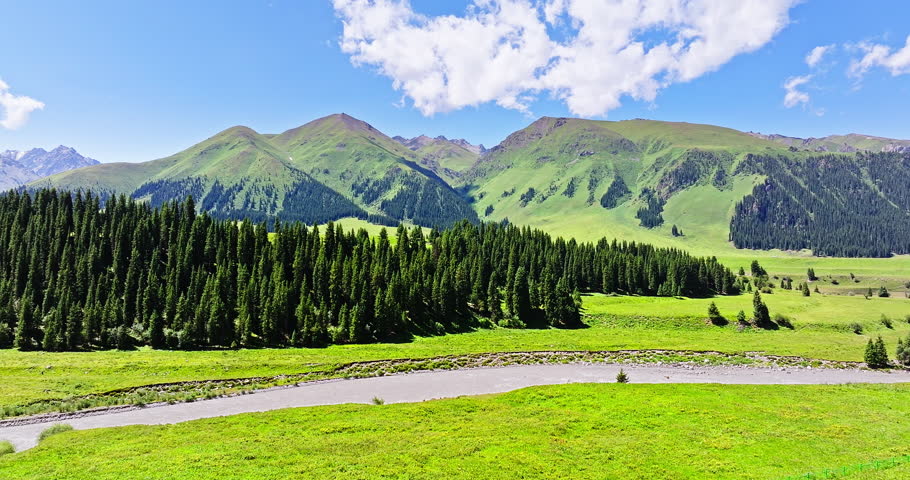 Beautiful mountain landscape with green meadow and river under blue sky