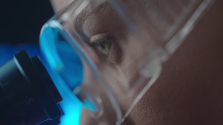 Female virologist scientist using microscope in laboratory. Biochemical and medical research. Pharmacist specialist working with lab equipment analyzing samples and searching for vaccine development