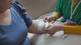 Midsection shot of unknown female medical worker in scrubs giving IV drip to elderly woman who undergoing vitamin therapy at home - Powered by Shutterstock - Get 15% off with code: PIKWIZARD15