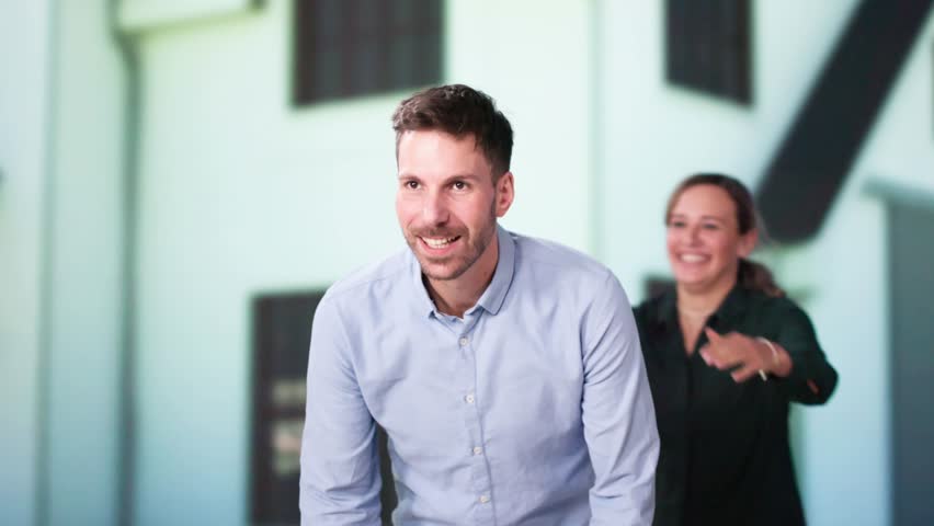Portrait Of A Happy Family Standing Outside Their House With Solar Panels On Roof
