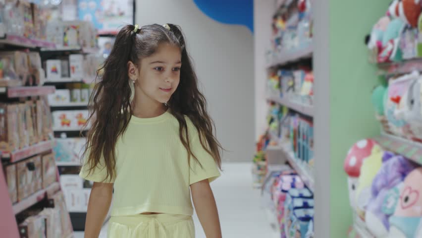 A young girl is joyfully exploring the colorful aisles filled with a variety of toys in a playful and inviting store environment that sparks her imagination and curiosity