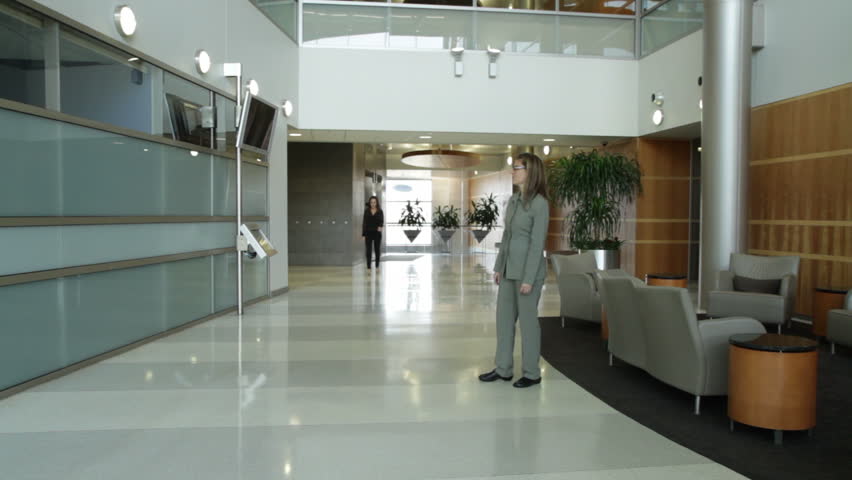 Various people passing through a modern office lobby, timelapse. Sped up footage