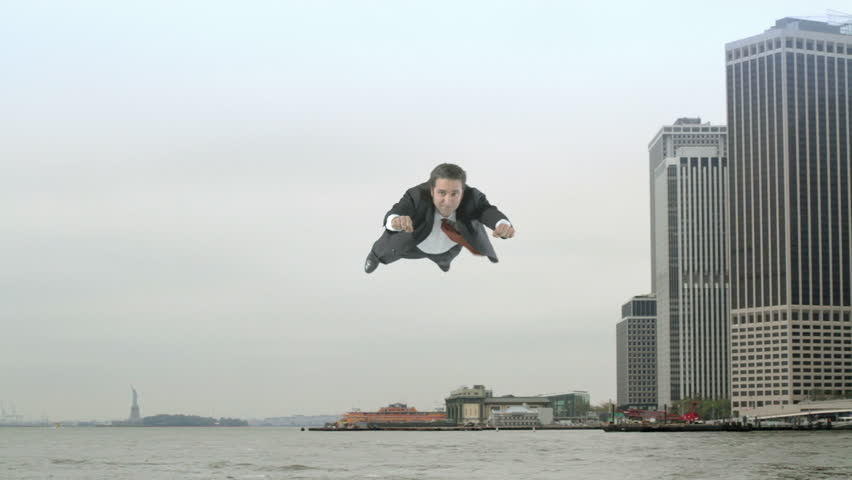 Man in a business suit flies from Manhattan's financial district and along the