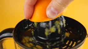 The process of squeezing orange juice on a citrus juicer on an orange background. - Powered by Shutterstock - Get 15% off with code: PIKWIZARD15