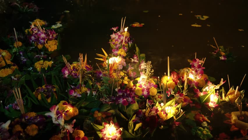 Floating Krathong With Flowers In The Water During The Yi Peng Lantern Festival In Chiang Mai, Thailand. - closeup shot