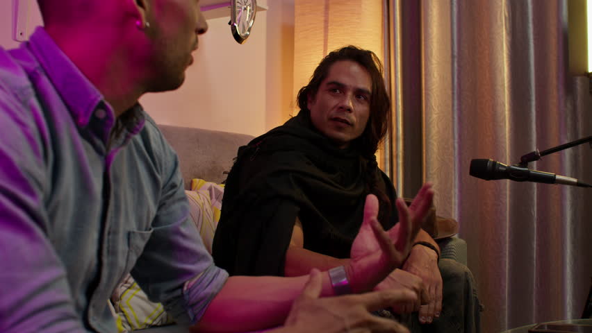 Two people discussing ideas passionately during a cozy podcast recording session