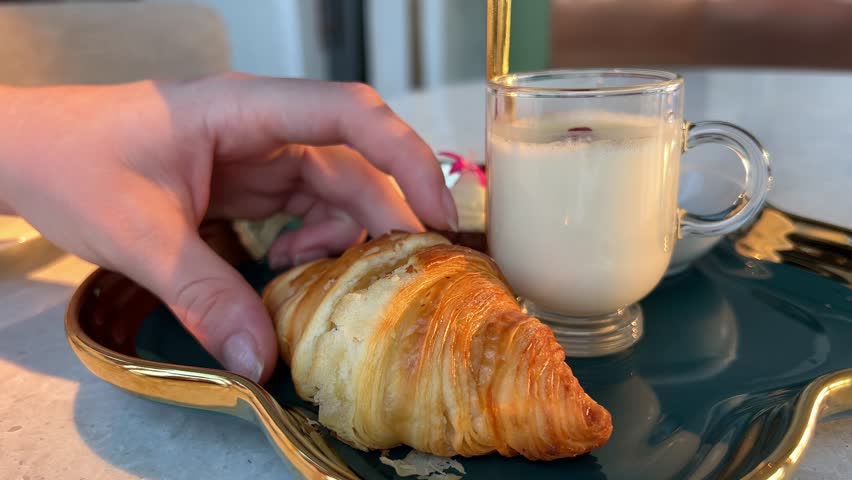 mini croissant with milk in the hands of girl. croissant structure