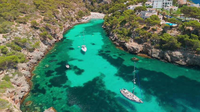 Aerial revealing view of the Bay of Cala Pi in Mallorca, Balearic Islands, Spain. Stunning Mediterranean Sea coast with turquoise water sea bay and white sand beach. Mallorca travel destinations