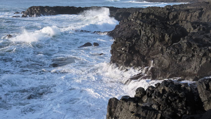 Huge waves crash on the shore, Rocky ocean coast in Iceland, Basalt cliff, Awesome power of waves breaking over dangerous rocks