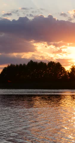 the beautiful orange sky is reflected in the water of the lake at sunset, the lake with orange water in the summer at sunset