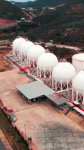 Gas plant with storage tanks. Oil and gas tanks on factory. Gas for clean electricity. Large gas storage tanks in refinery. Vertical video