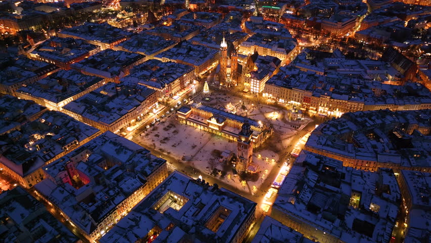 Winter wonderland in Krakow's market square with Saint Mary Basilica illuminated at night