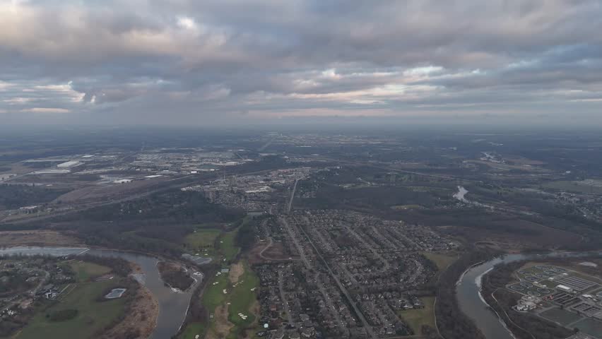 An aerial view of dramatic cloudy sky above the urban Kitchener, Ontario cityscape in Canada, creating calm atmosphere over the city at sunset time
