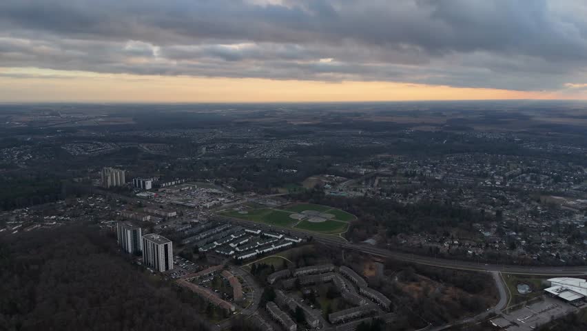 An aerial view captures the city of Kitchener, Ontario from above, under a serene blanket of clouds at sunset time in Canada