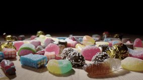 Assorted sugary sweet candy falls onto table top, macro dolly shot - Powered by Shutterstock - Get 15% off with code: PIKWIZARD15
