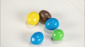 Video of chocolate jelly beans of different colours falling on a white background. Concept: Chocolate, jelly beans, candy. - Powered by Shutterstock - Get 15% off with code: PIKWIZARD15