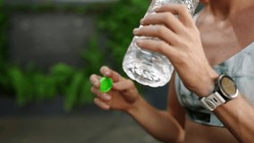 Exhausted sportswoman rehydrates, gulping water after intense training in posh, open-air fitness space in lush greenery. Refreshed, she takes a breather, surrounded by serene, opulent nature. Slowmo - Powered by Shutterstock - Get 15% off with code: PIKWIZARD15