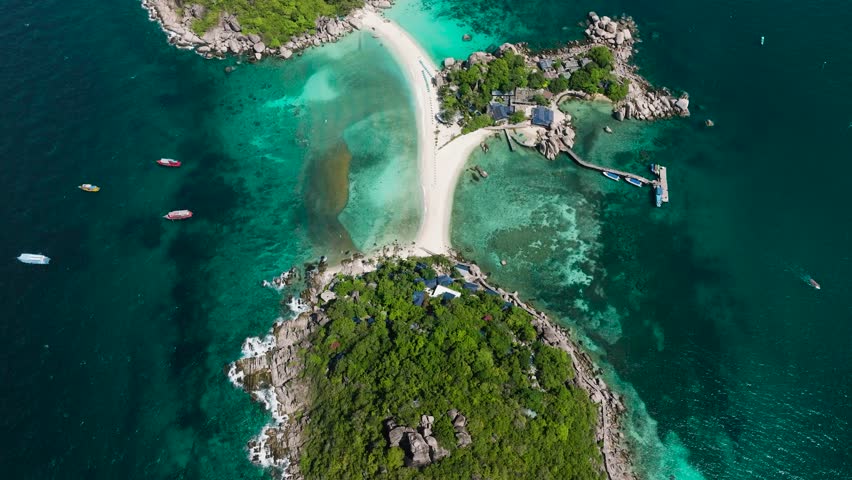 A green island with sandy beaches surrounded by turquoise waters, vibrant marine life, and a peaceful ambiance. Ko Nang Yuan, Thailand.
