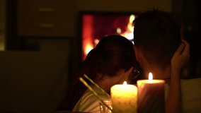couple sits close together, their silhouettes illuminated by warm glow of candles and a cozy fireplace - Powered by Shutterstock - Get 15% off with code: PIKWIZARD15
