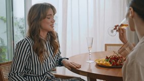 Joyful besties drinking wine at apartment meeting closeup. Women laughing joking together at kitchen table. Happy brunette enjoy cheerful conversation at home holding glass goblets. Friendship concept - Powered by Shutterstock - Get 15% off with code: PIKWIZARD15
