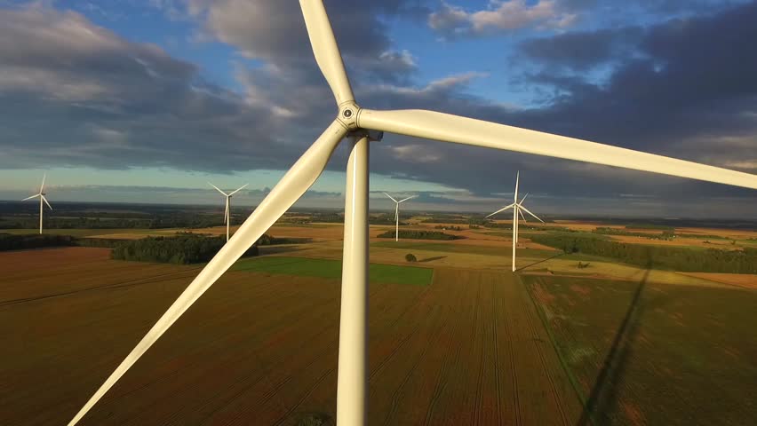 Windmills in Beautiful Nature, Landcape. Sustainable power. Aerial view of wind turbines. Alternative Eco Energy Wind Turbine in Beautiful Green Landscape at Sunset. Aerial drone view