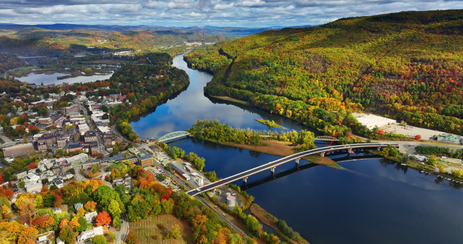 Beautiful river flowing through the landscape of Vermont, New England, USA. Autumn scenery of the city from top.