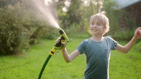 Funny boy pouring cool water on himself and playing with garden hose with sprinkler in sunny backyard on hot summer day. Happy child having fun with water splashes. Summer outdoor activity for kids. - Powered by Shutterstock - Get 15% off with code: PIKWIZARD15