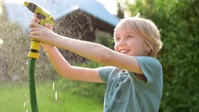 Funny boy pouring cool water on himself and playing with garden hose with sprinkler in sunny backyard on hot summer day. Happy child having fun with water splashes. Summer outdoor activity for kids. - Powered by Shutterstock - Get 15% off with code: PIKWIZARD15