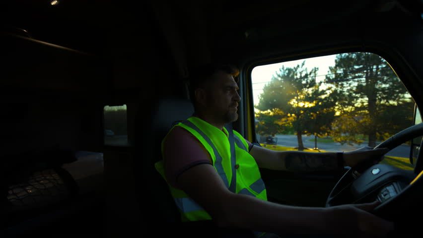 Professional Semi Truck Driver is riding on beautiful sunny day. Shot from inside the truck