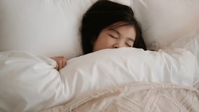 A Japanese girl sleeping in bed - Powered by Shutterstock - Get 15% off with code: PIKWIZARD15