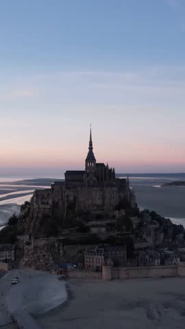 DRONE AERIAL FOOTAGE: The Mont Saint Michel and its bay at the sunset. The Abbey of Mont-Saint-Michel in Normandy, France.