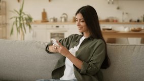 Happy smiling user at home own apartment relaxed smile positive satisfied Indian woman Arabian girl female lady holding mobile phone using smartphone shopping online chat app online internet message - Powered by Shutterstock - Get 15% off with code: PIKWIZARD15