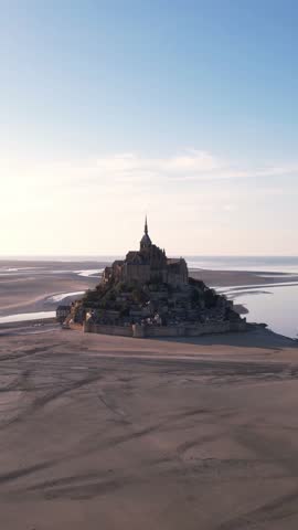 DRONE AERIAL FOOTAGE: The Mont Saint Michel and its bay at the sunset. The Abbey of Mont-Saint-Michel in Normandy, France.