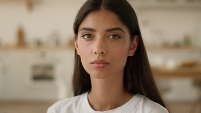 Portrait at home own apartment serious calm confident negative Indian woman Arabian girl female lady wife girlfriend mother looking at camera upset face problem trouble homeowner mortgage insurance