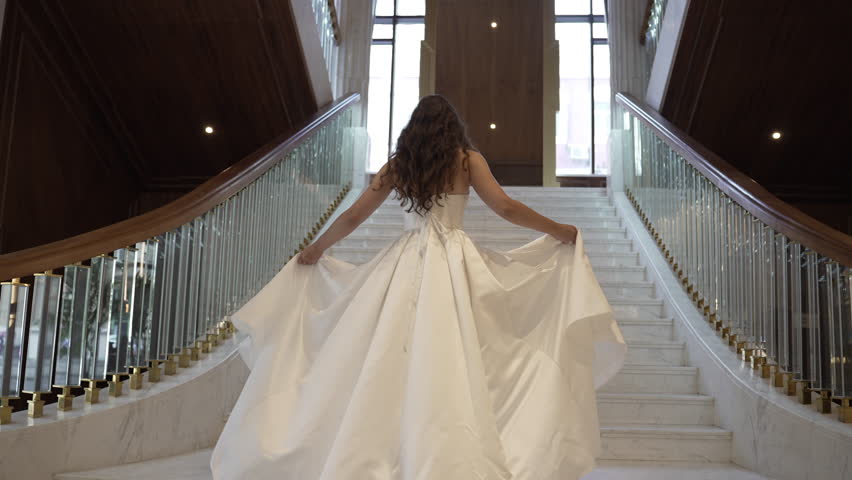 Elegant Bride Ascending the Stairs in a Stunning Wedding Dress