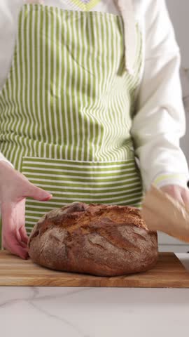 hands put brown whole sourdough bread in paper shopping bag bakery concept