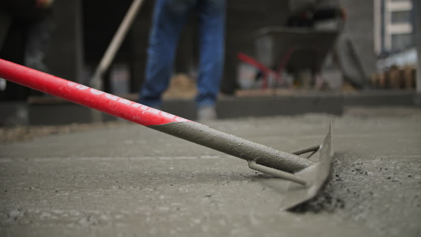 Workers Leveling Wet Concrete at Construction Site