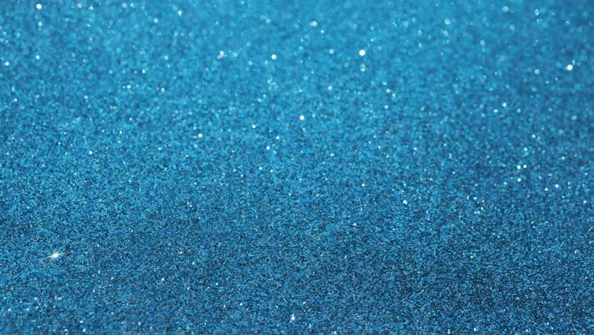 Footage of a man rolling a dice on a blue glittery background showing the number one on the dice