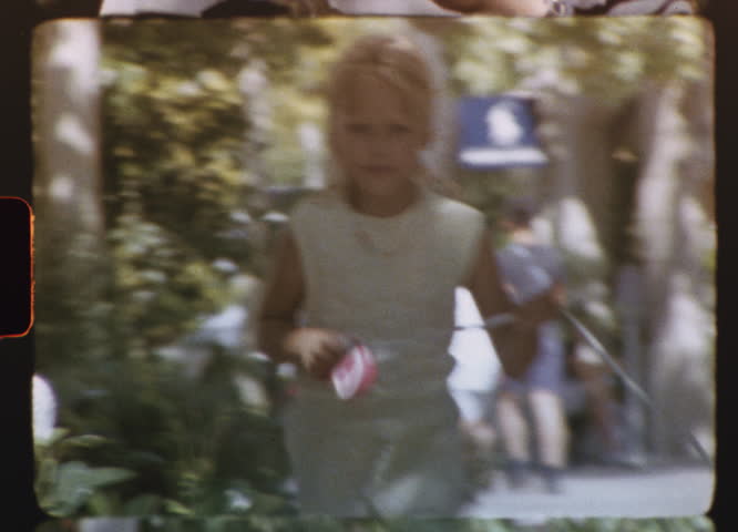 Nostalgic 8mm video capturing carefree childhood moment, young girl running joyfully with pet dog through sunlit urban shopping mall during vintage summer day