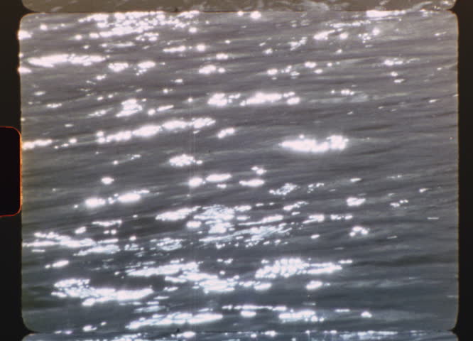 Sunlight is reflecting on a water surface, creating a beautiful, sparkling effect, with a retro 8mm film aesthetic