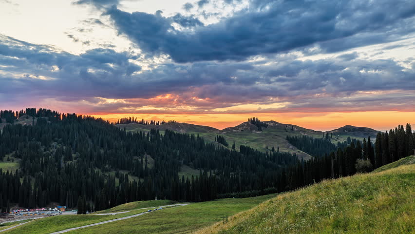 Dreamy sky sunset clouds over green forest and mountain. Summer landscape.