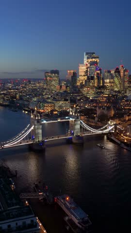 Panoramic aerial night view of the illuminated Tower Bridge and skyline of London, England