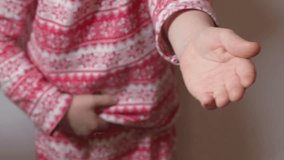 Child in winter red white pajamas with snowflakes asks for donut on gray background, Close-up in 4K, UHD - Powered by Shutterstock - Get 15% off with code: PIKWIZARD15