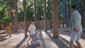 Father son playing football in sunshine park. Happy family running with ball in sunny nature. Carefree daddy kid enjoying summer activity together. Active man boy soccer game in sunlight garden place - Powered by Shutterstock - Get 15% off with code: PIKWIZARD15