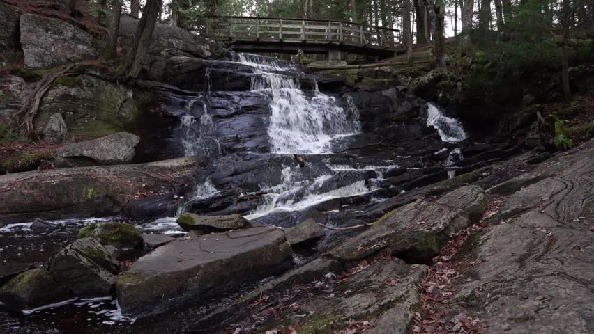 A drone view revealing high cascading waterfalls in High Falls Park, Bracebridge, Ontario, Canada, during evening