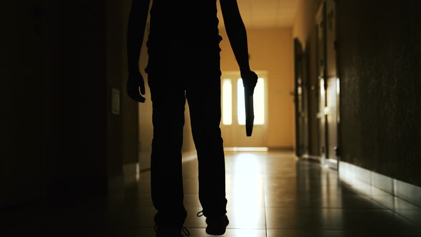 Lonely silhouette of child go down dark corridor towards door light. Child's path to light. Boy child in dark empty corridor. Little boy looks out of window. Primary school looking to future of child