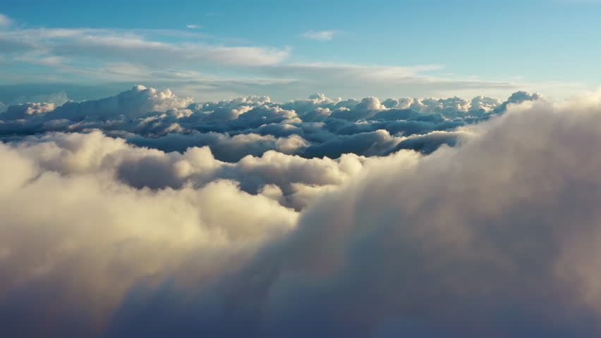 Flying above the clouds. Aerial view of clouds at sunrise. Traveling by air perfect background, 4k