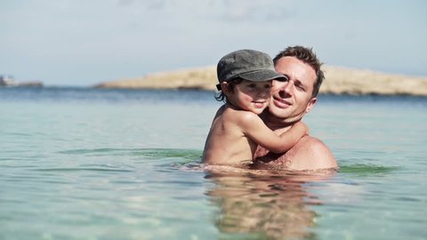 Father and son playing in the sea
 Video de stock